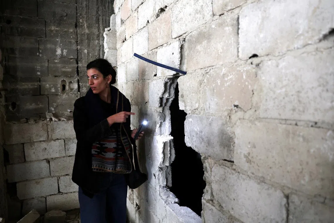 Hiba Zayadin, the Syria researcher at advocacy group Human Rights Watch, checks behind a wall in Tadamon district, which is littered with bones after what residents and rights groups described as years of killings there under the rule of Syria's Bashar al-Assad, following al-Assad's ousting by fighters of the ruling Syrian body, in Damascus, Syria, December 12, 2024. REUTERS/Amr Abdallah Dalsh