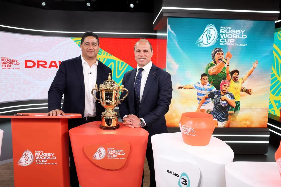 Australian former rugby union players Morgan Turinui and Phil Waugh pose with the Webb Ellis Cup during the 2027 Rugby World Cup draw at Channel Nine Studios in Sydney on Dec 3, 2025.