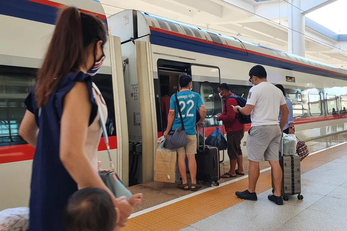 Passengers boarding the Laos-China Railway train at Vientiane station. 