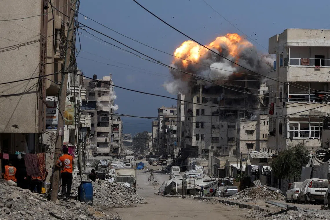 Smoke and flames rise from a residential building hit by an Israeli strike, in Gaza City July 21, 2025. REUTERS/Khamis Al-Rifi     TPX IMAGES OF THE DAY