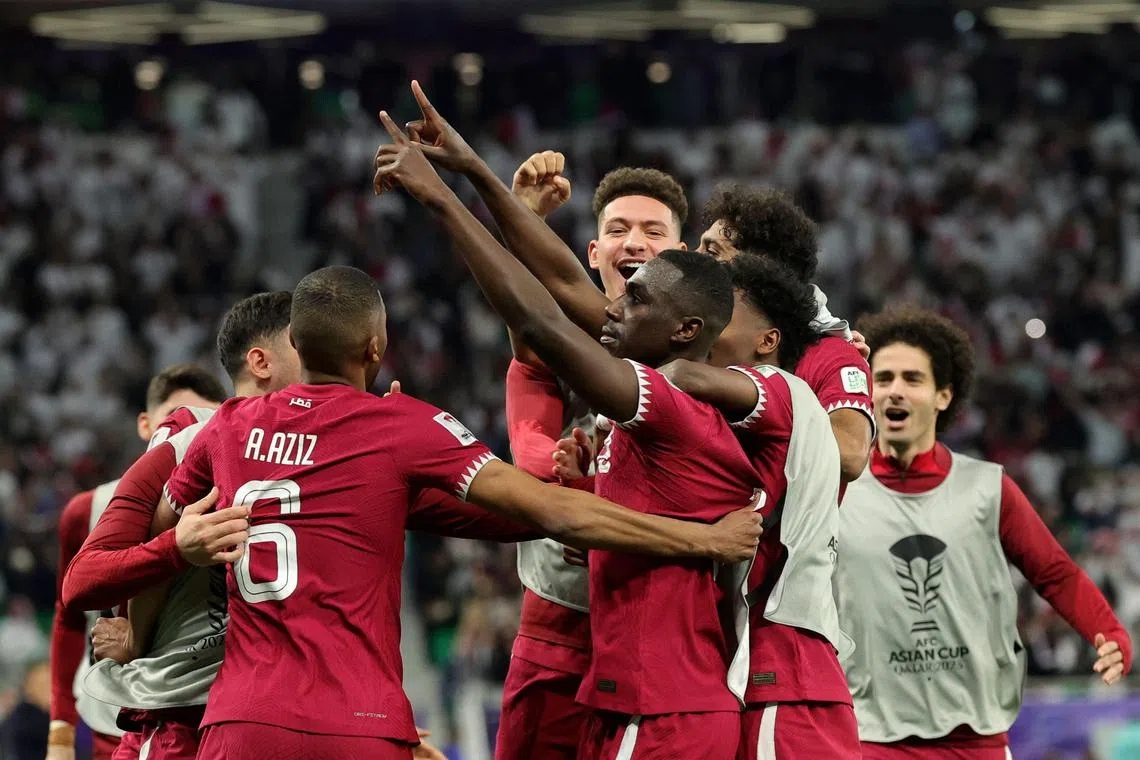 Qatar forward Almoez Ali (centre) celebrates with teammates after scoring his team's third goal.
