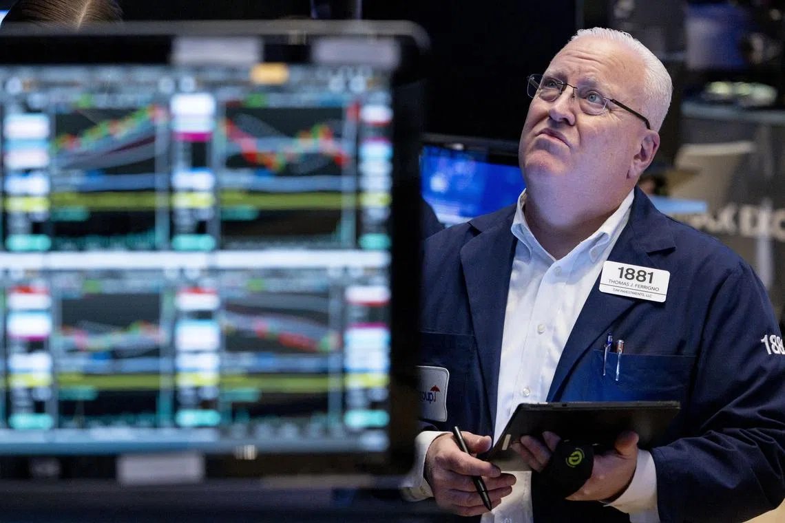 A trader works on the floor of the New York Stock Exchange as markets react to financial news indicating lower inflation in the US economy.