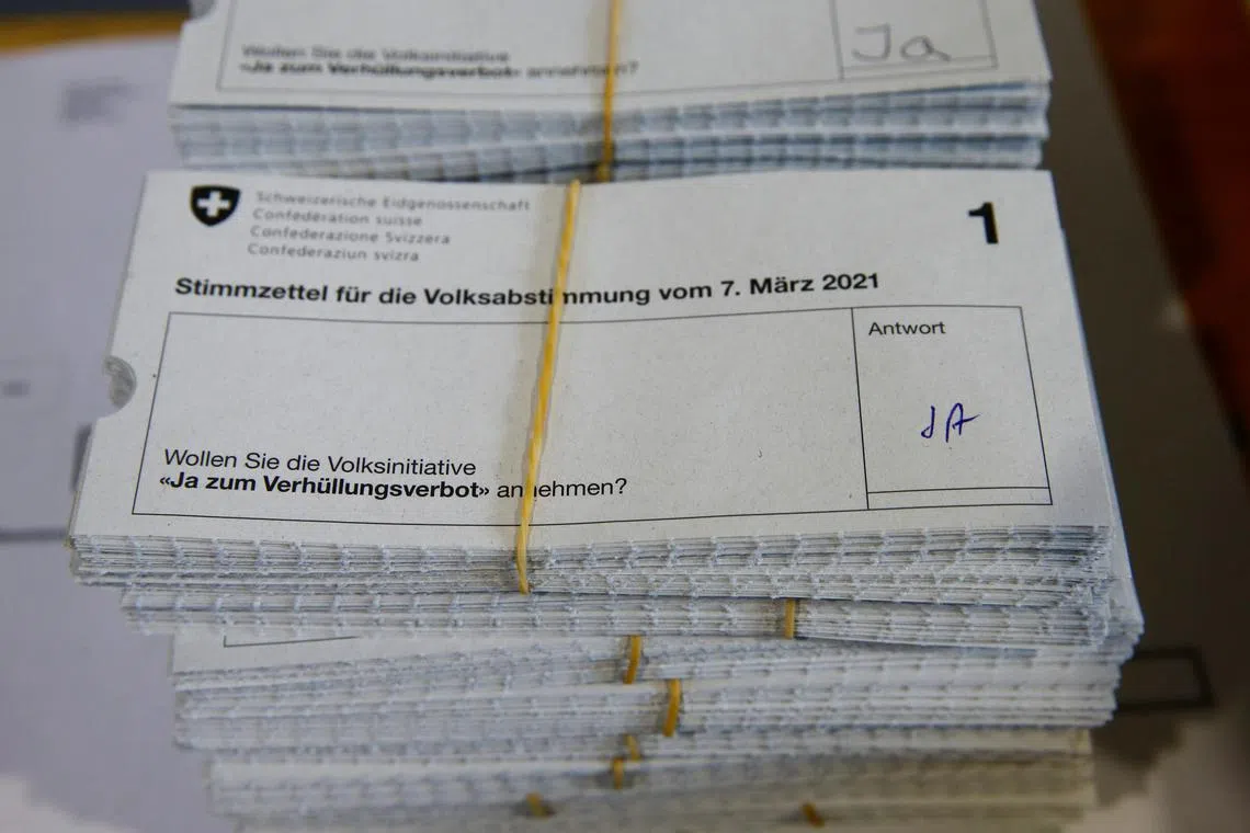 Piles of \"Yes\" ballots sit on a table at the district election office Stadtkreis 3 on the day of a Swiss referendum on banning burqas and other facial coverings, in Zurich, Switzerland March 7, 2021. REUTERS/Arnd Wiegmann/File Photo