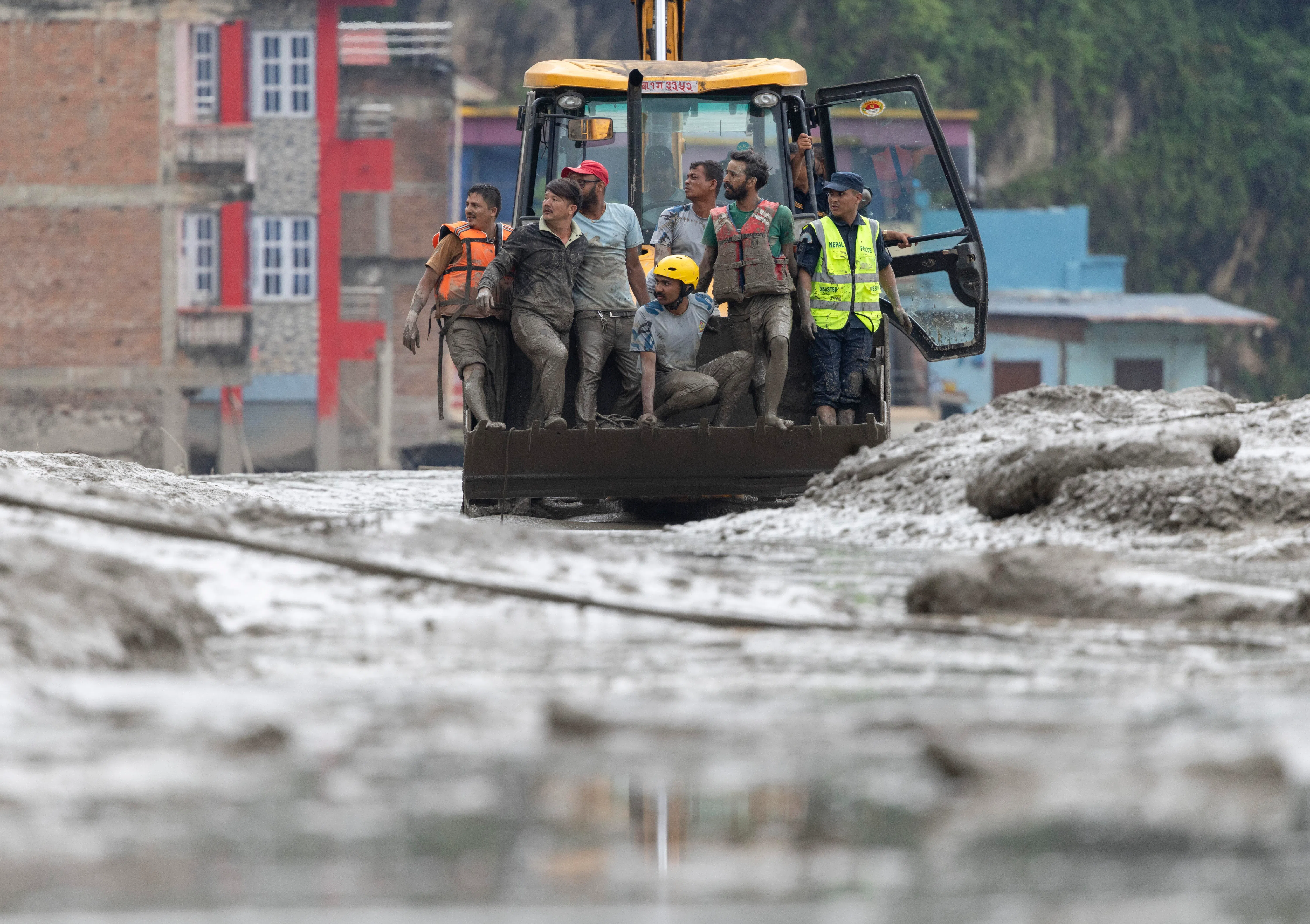 Rescuers riding in an excavator at Devighat village, following a flash flood in Trishuli Bazar, in Nepal’s Nuwakot district, on Aug 26.