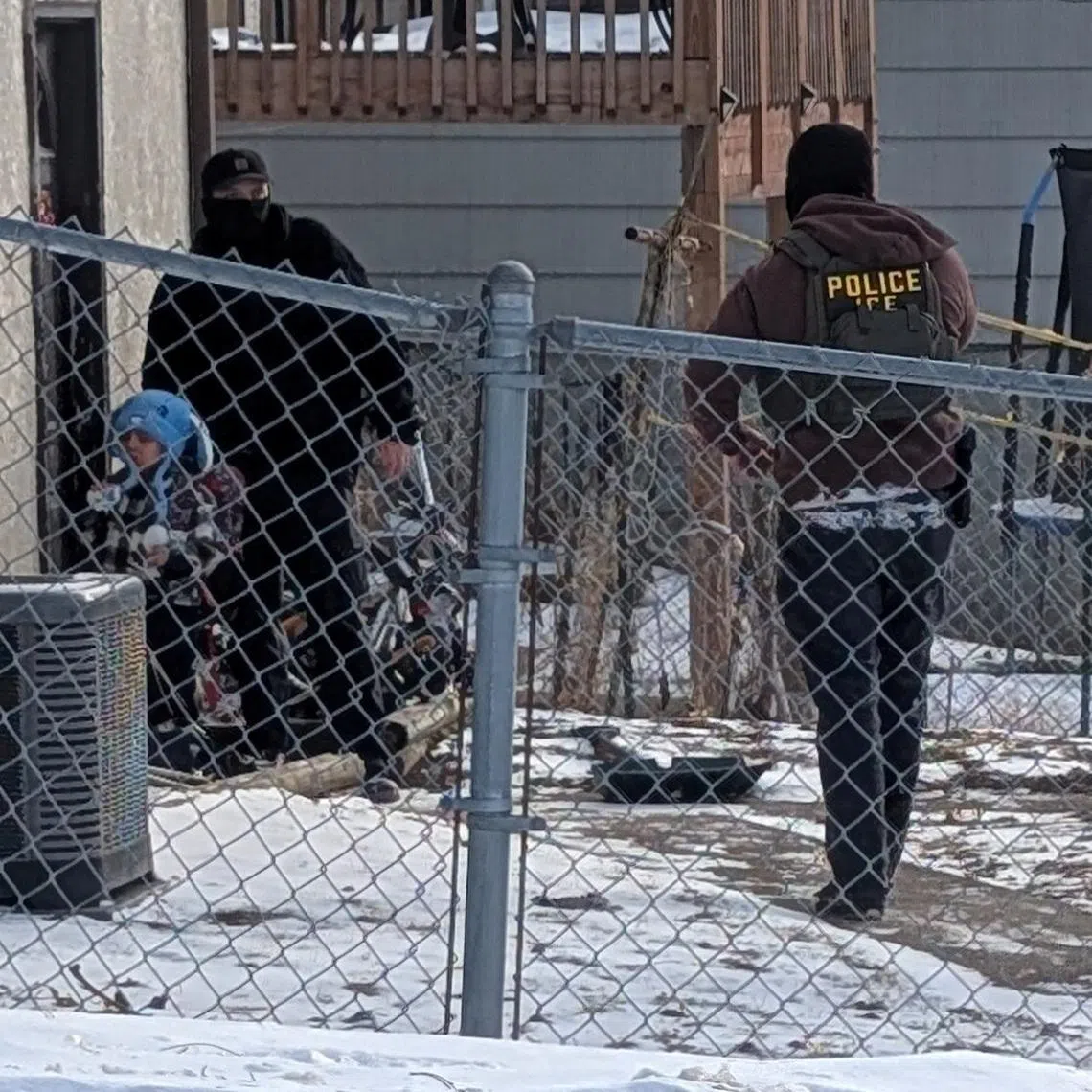 ICE agents stand next to a boy, who a witness identified as Liam Conejo Ramos, a five-year-old that  school officials said was detained in Minneapolis, Minnesota, U.S., January 20, 2026.  Rachel James/via REUTERS/File Photo