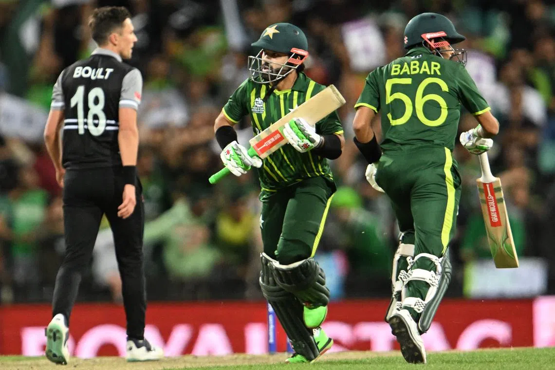 Pakistan's Muhammad Rizwan (centre) runs between the wickets with captain Babar Azam as New Zealand's Trent Boult looks on during the T20 World Cup semi-final match at the Sydney Cricket Ground on Nov 9, 2022.