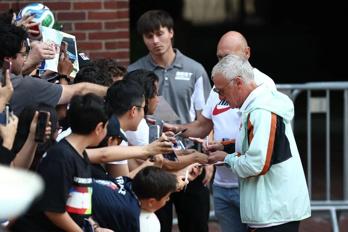 France’s head coach Didier Deschamps signing autographs as the team depart from their hotel to travel to Miami on July 16.