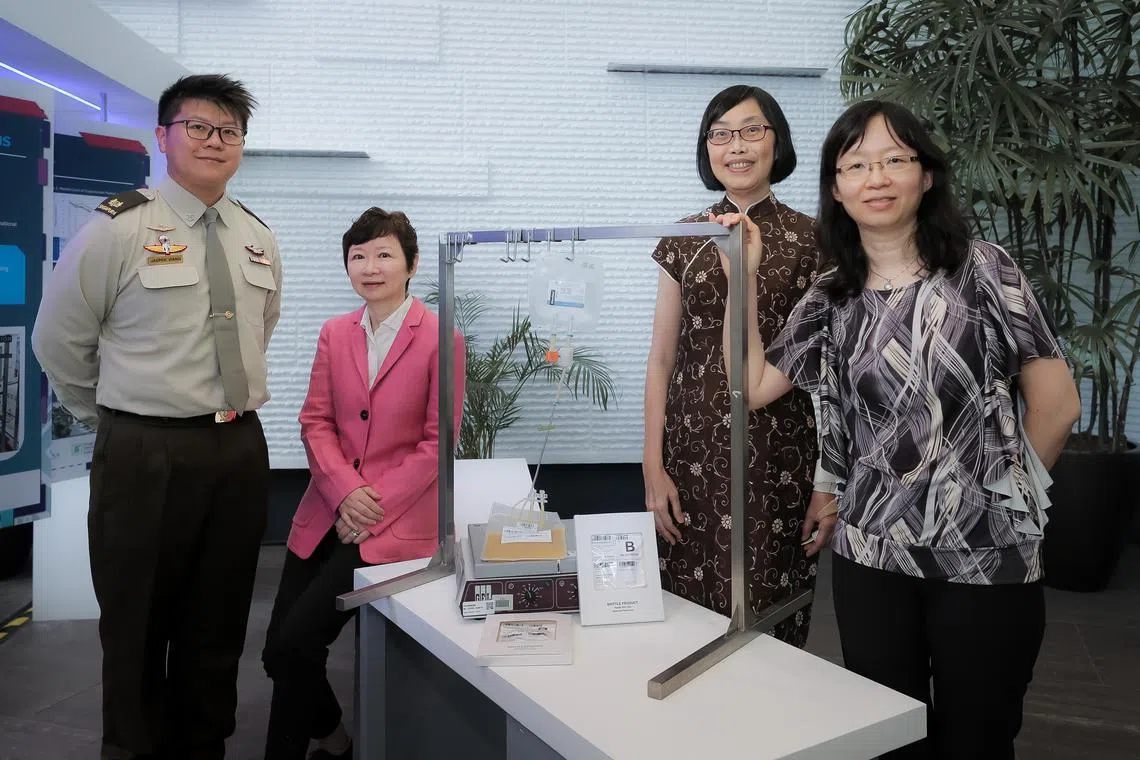 From left: MAJ (Dr) Jasper Wang, DSO National Laboratories programme director Associate Prof Lu Jia (pink), HSA Blood Services Group assistant group director Dr Tan Hwee Huang (brown) and SGH Haematology Department senior consultant Dr Ang Ai Leen (black white pattern) at their exhibition booth during the Defence Tech Prize (DTP) Awards ceremony held at the DSTA Auditorium, 20 Oct 2022. The four were part of a team  that developed a method to cryogenically preserve blood platelets to increase its shelf life.