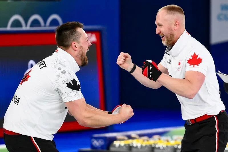 Canada's Ben Hebert (left) and Brad Jacobs celebrate becoming Olympic Champions after defeating team GB in the curling men's gold medal game on Feb 21, 2026.