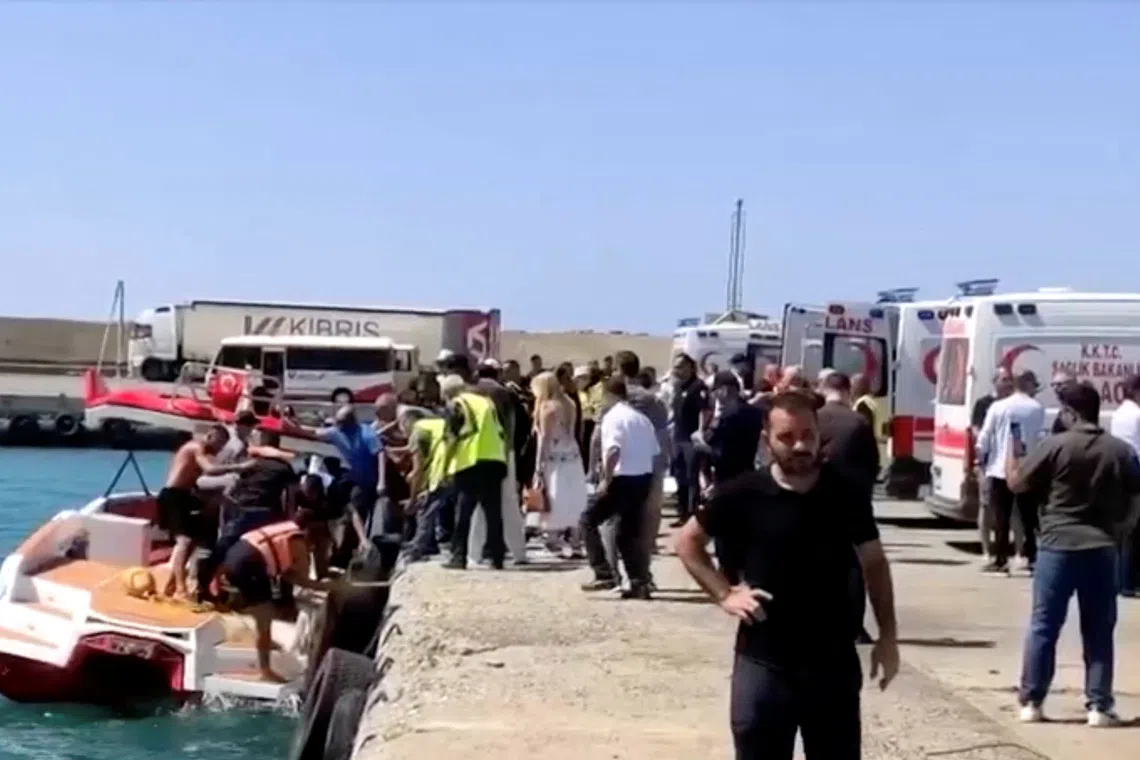 Rescue boats bring passengers to shore from capsized boat in northern Cyprus, Aug 30.