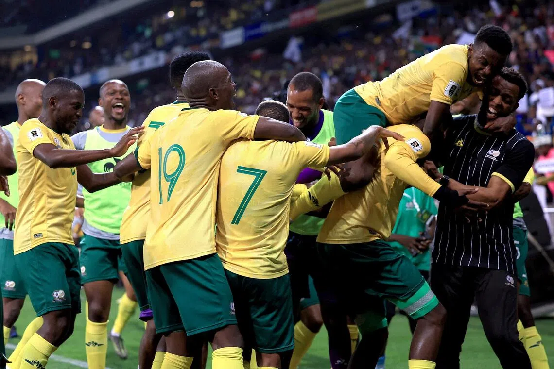 South Africa's Evidence Makgopa celebrates scoring their third goal with teammates.