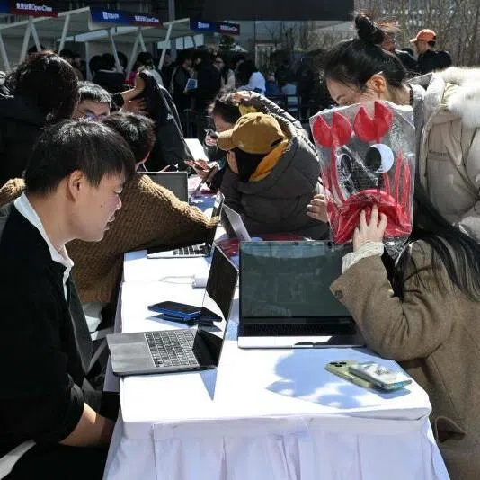 Engineers (left) install and set OpenClaw, an open-source AI assistant for users at the Baidu headquarter in Beijing on March 11. 