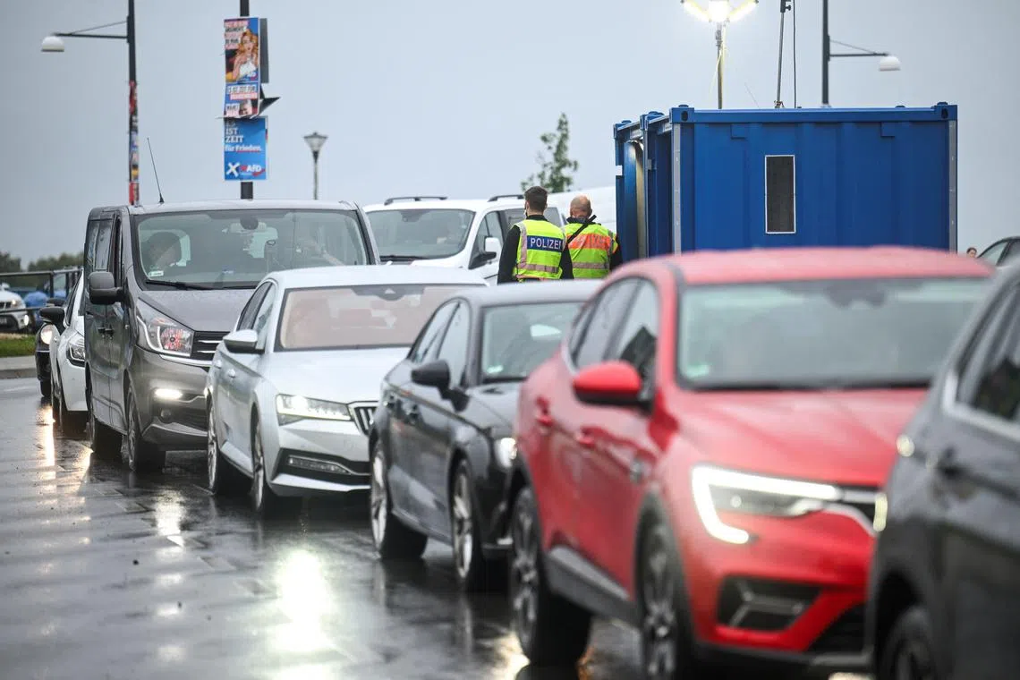 Vehicles pass by a checkpoint as police officers stand by, on the German-Polish border crossing \"Stadtbruecke\", as all German land borders are subject to random controls to protect internal security and reduce irregular migration, in Frankfurt (Oder), Germany September 16, 2024. REUTERS/Annegret Hilse