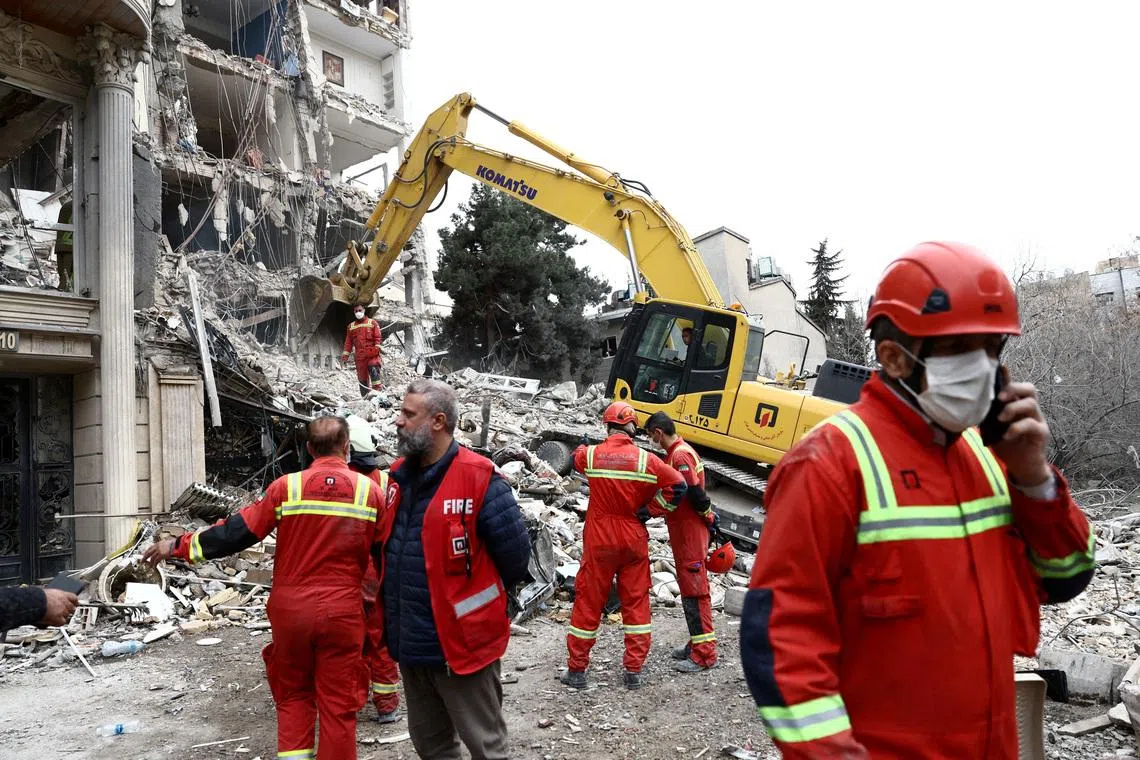 Emergency personnel working at the site of a strike on a residential building, amid the US-Israeli conflict with Iran, in Tehran, Iran, March 23.