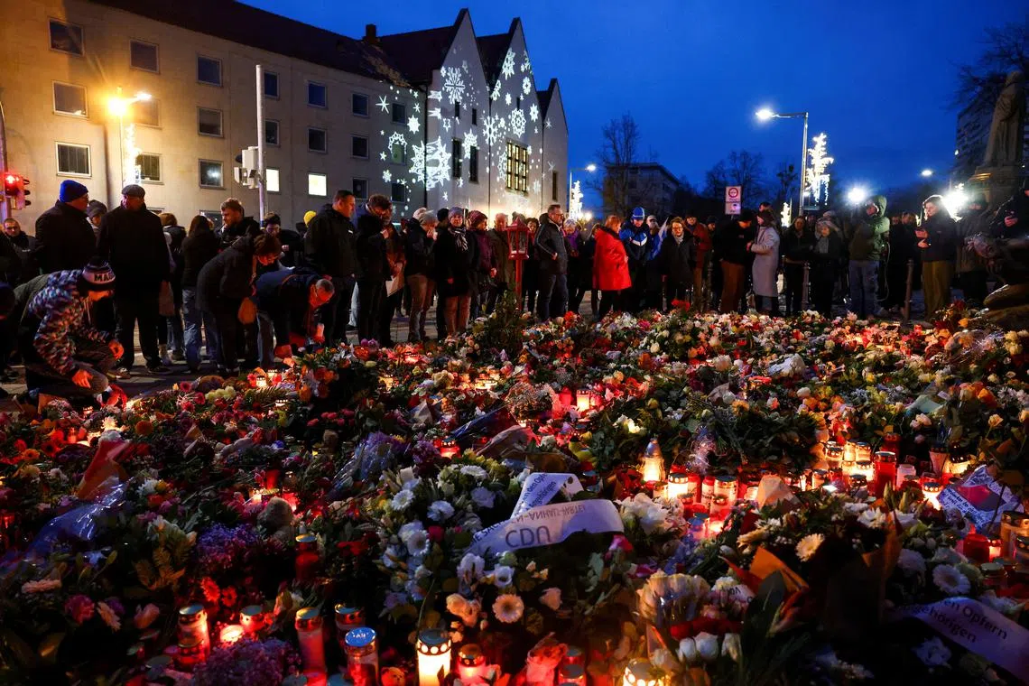 Plush toys, candles and floral tributes lie near the site where a car drove into a crowd at a Magdeburg Christmas market in Magdeburg, Germany December 21, 2024. REUTERS/Christian Mang