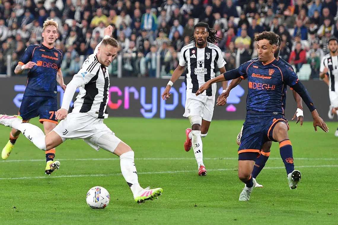 Juventus' Teun Koopmeiners taking a shot as Lecce's Kalonda Gaspar blocks him during their Italian Serie A soccer match at Allianz Stadium in Turin, Italy on April 12, 2025.
