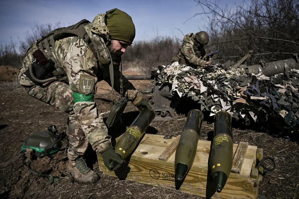 A Ukrainian serviceman prepares a shell for firing at Russian positions near Bakhmut, on March 14, 2023.