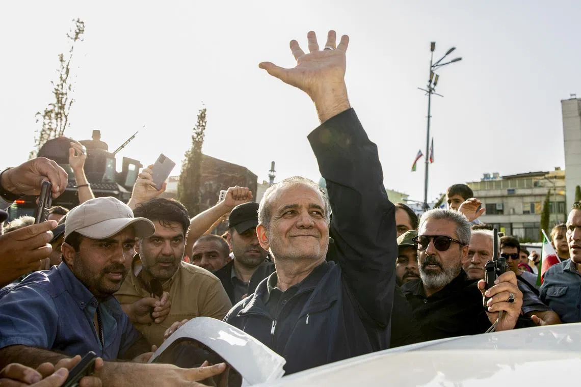 Iranian President Masoud Pezeshkian waving as he leaves a protest, following  attacks by the US on Iranian nuclear sites.