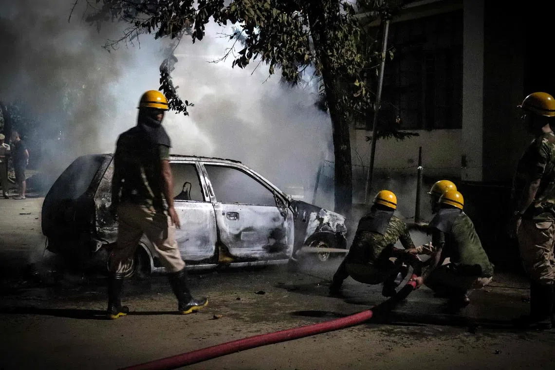 Firefighters douse a vehicle torched by protesters in Imphal, in India's northeastern state of Manipur, amid ongoing ethnic violence.