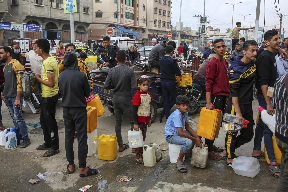 People queue for fuel in Khan Younis, in the central Gaza Strip, during the second day of a temporary negotiated cease-fire between Israel and Hamas.