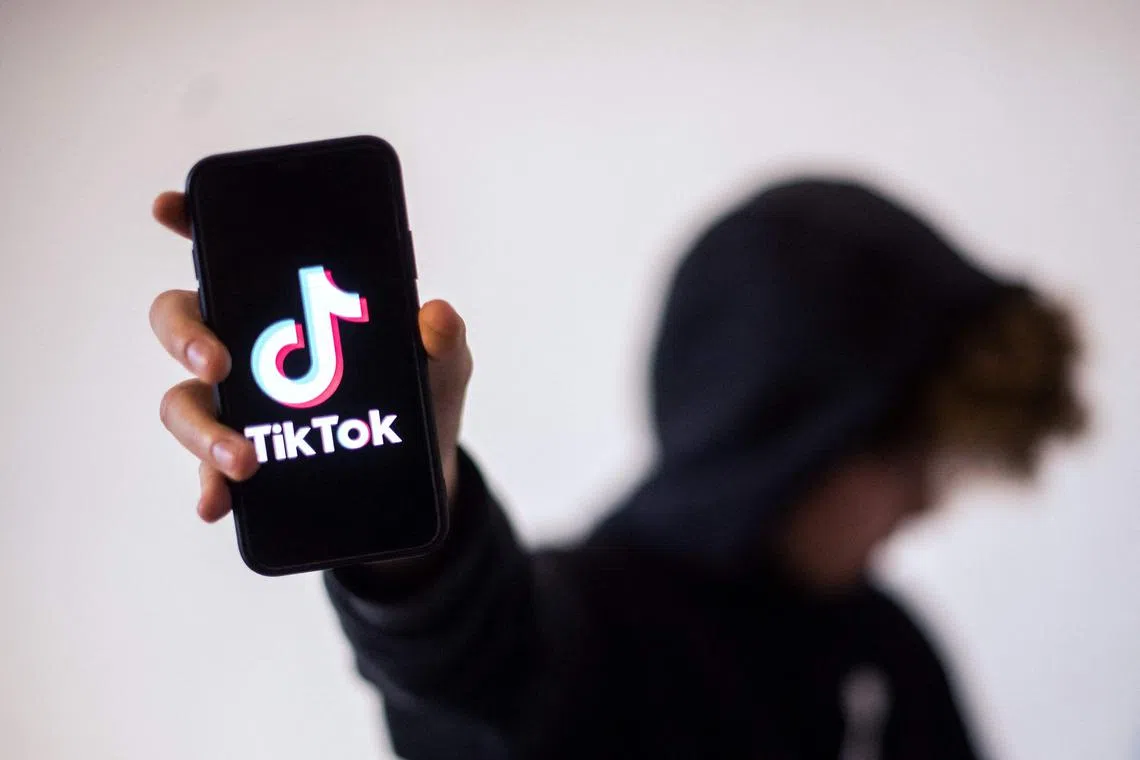 (FILES) In this file photograph taken on January 21, 2021, a teenager poses presenting a smartphone with the logo of social network TikTok in Nantes, western France. - A Moscow court on April 6, 2021, has fined TikTok more than USD30,000 for failing to delete posts calling for minors to join unsanctioned protests in support of jailed Kremlin critic Alexei Navalny. The court said on its Telegram channel that the video-sharing platform had been found guilty of failing to remove information that violates Russian law and sentenced to an administrative fine of 2.6 million rubles (USD34,000, 28,000 euros). (Photo by LOIC VENANCE / AFP)