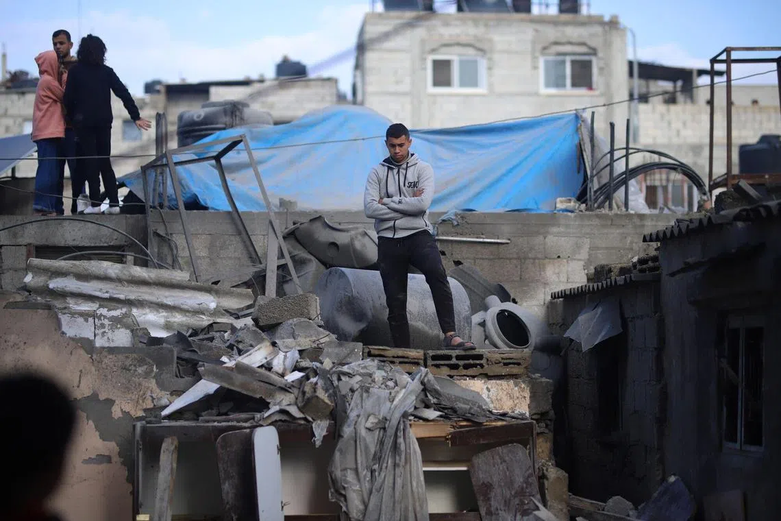 Palestinians sift through the rubble of a building levelled by an Israeli airstrike in Rafah, southern Gaza.
