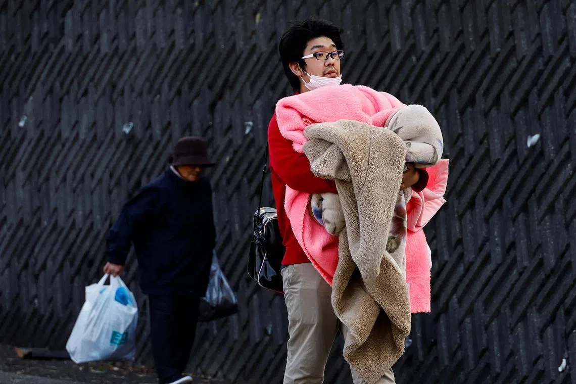 Residents in Fukamimachi, a village isolated after the earthquake, heading to a Japan Self-Defense Forces (JSDF) rescue helicopter, in Wajima, Ishikawa Prefecture, Japan, Jan 6, 2024. 
