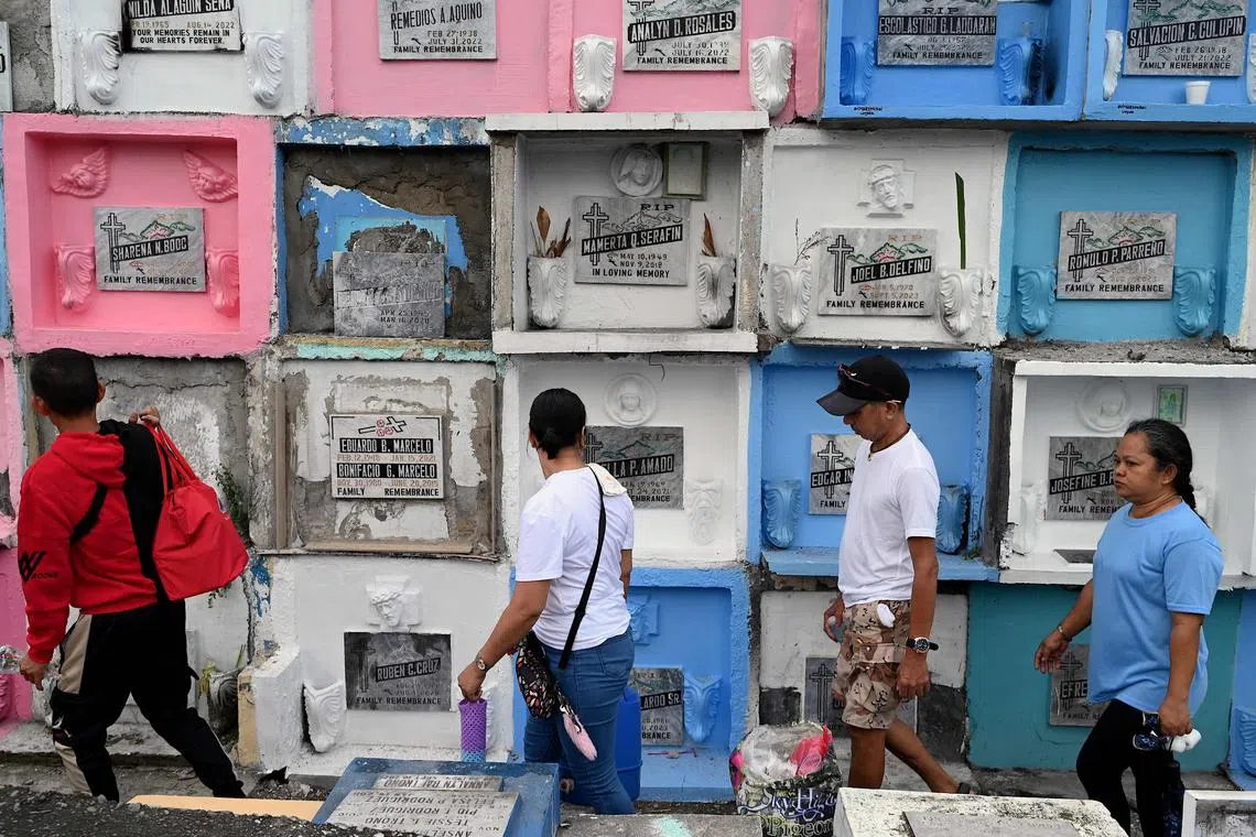 People walk past tombs at the Manila North Cemetery on All Saints’ Day on Nov 1, 2023.
