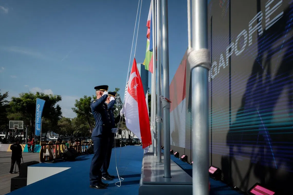 Ceremonial guards raising the Singapore flag at the SEA Games national flag raising ceremony at the open area beside Hua Mark Indoor Stadium on Dec 8, 2025.