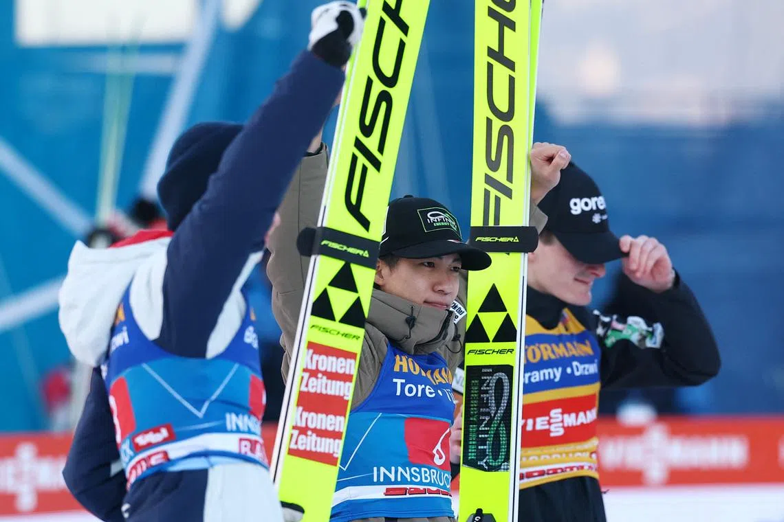 Ski Jumping - Four Hills Tournament - Innsbruck, Austria - January 4, 2026 Japan's Ren Nikaido celebrates after winning the Men's Individual HS128 alongside second place Slovenia's Domen Prevc and third place Austria's Stephan Embacher REUTERS/Kai Pfaffenbach