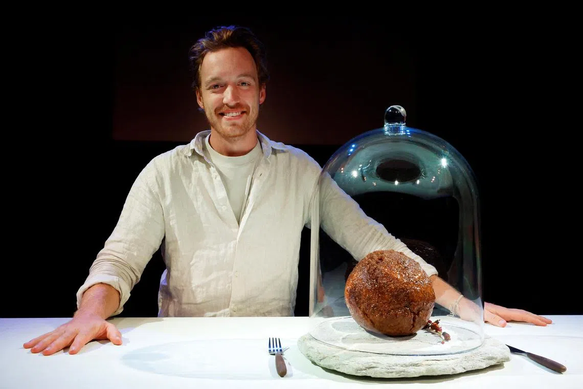 Founder of Australian alternative protein start-up Vow Tim Noakesmith with a meatball made from flesh cultivated using the DNA of the extinct woolly mammoth. 