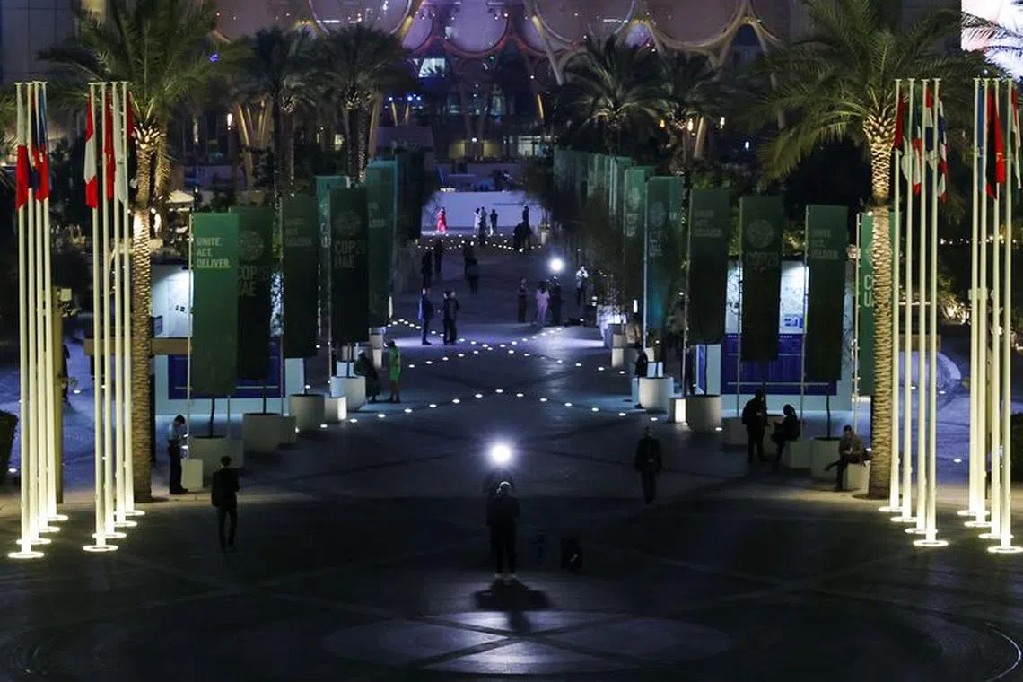 TV reporters work, as draft of COP28 deal is negotiated at the same time, during the United Nations Climate Change Conference (COP28) in Dubai, United Arab Emirates, December 12, 2023. REUTERS/Amr Alfiky/File Photo