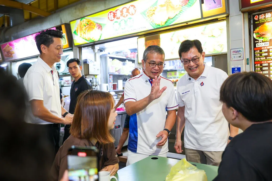Minister for Culture, Community and Youth Edwin Tong (centre) and Deputy Prime Minister and East Coast GRC MP Heng Swee Keat (right) on a walkabout at the food centre at Block 16 Bedok South Road on March 23.