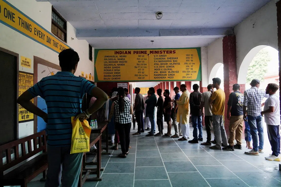 FILE PHOTO: People wait in line outside a polling station to vote during the state assembly elections, in Karnal in the northern state of Haryana, India, October 5, 2024. REUTERS/Bhawika Chhabra/File Photo