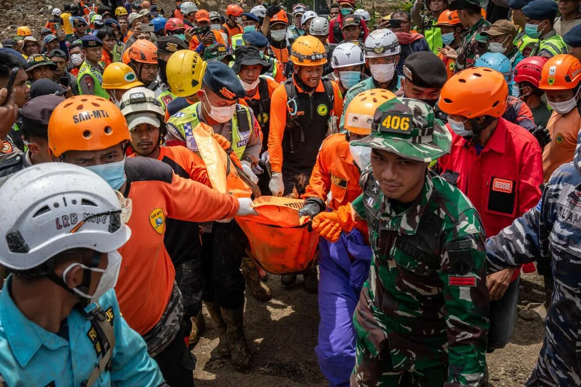 Rescue personnel carrying a victim during their recovery operation in Banjarnegara on Nov 20. 