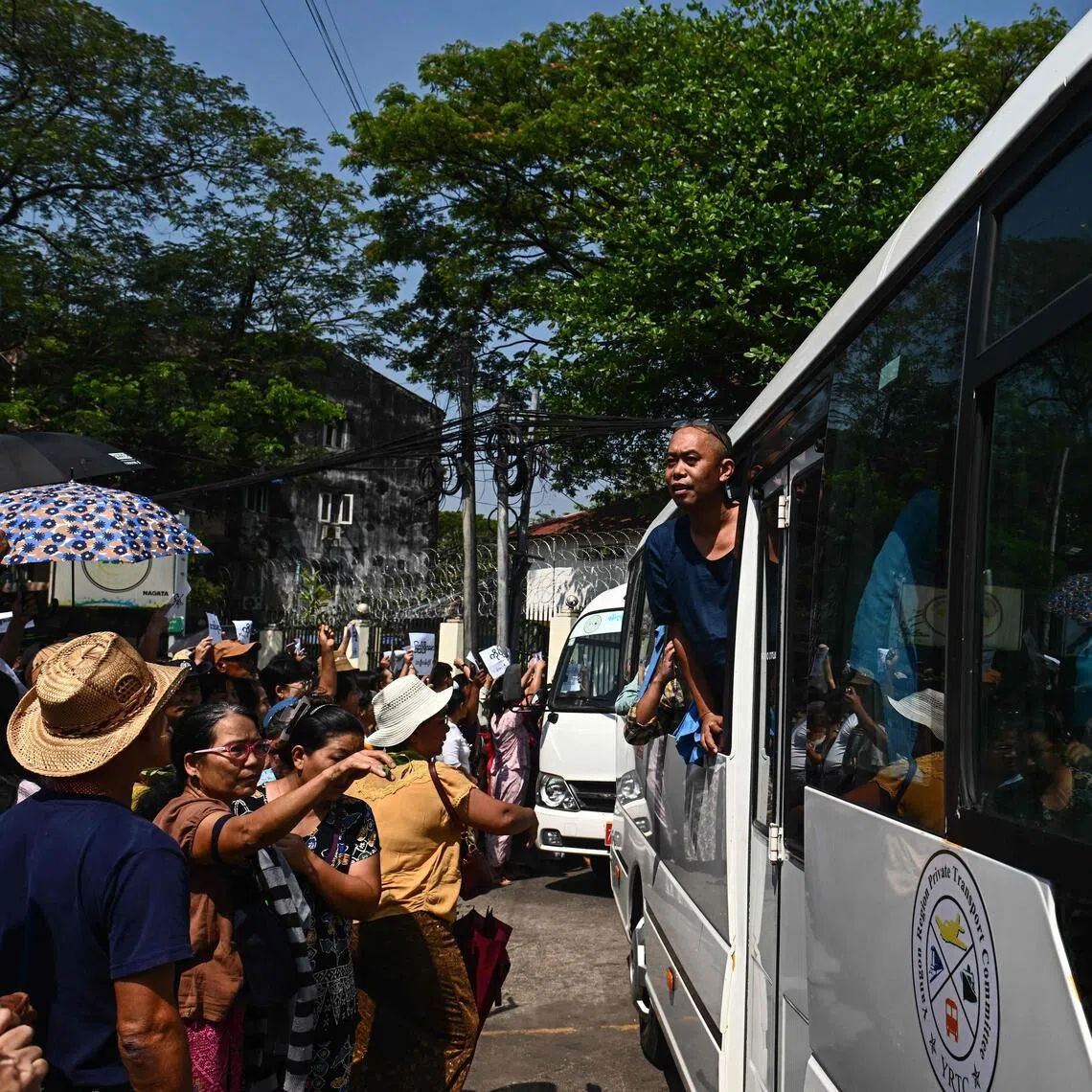 A prisoner looks out of a bus carrying fellow released prisoners out of Insein prison in Yangon on March 2, 2026, to mark Peasants' Day.