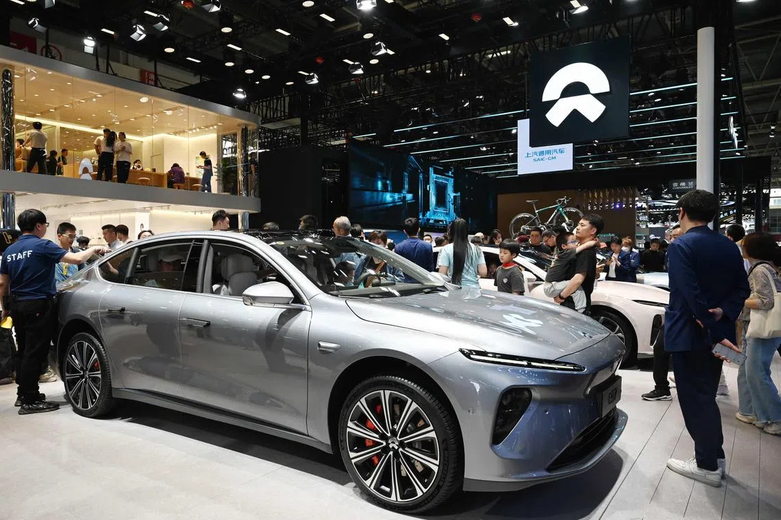 (FILES) People look at a Nio ET7 at the Beijing Auto Show in Beijing on May 3, 2024. China's electric car maker Nio said on July 4, 2024 it was aiming for a resolution with the European Union after the bloc announced tariffs on Chinese-made EVs. (Photo by GREG BAKER / AFP)