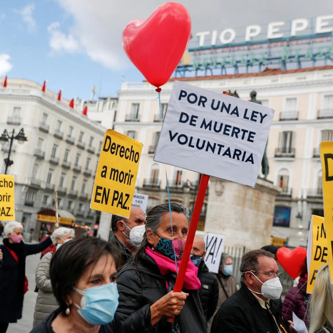 FILE PHOTO: Supporters of a law to legalise euthanasia gather as the Spanish Parliament votes to approve it in Madrid, Spain, March 18, 2021. The banners read: \"Right to die in peace\", \"For a law to die voluntarily\" REUTERS/Susana Vera/File Photo