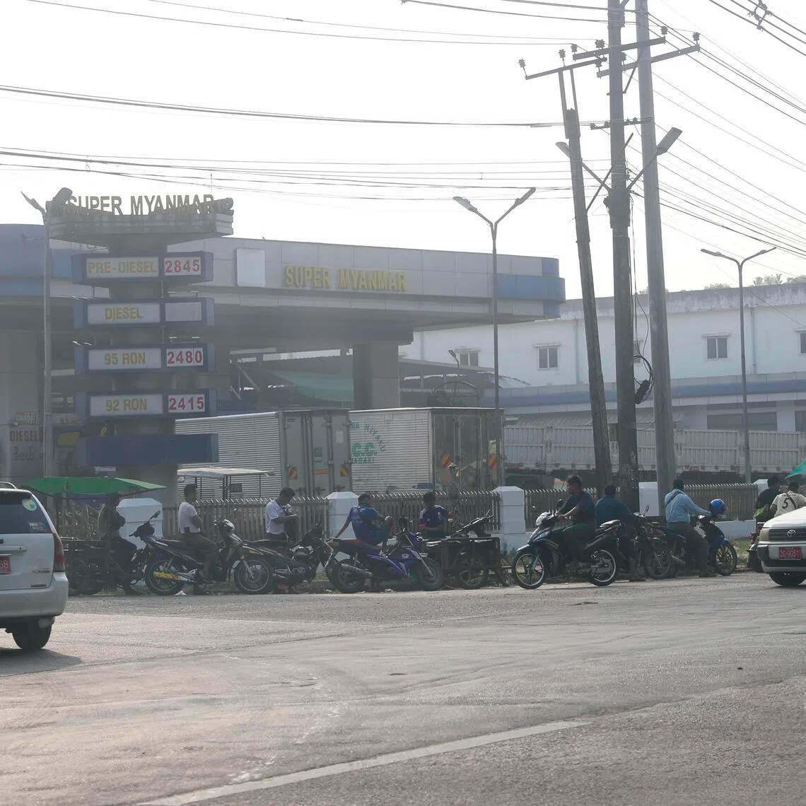 Motorbikes and cars queue at a petrol station in Yangon.