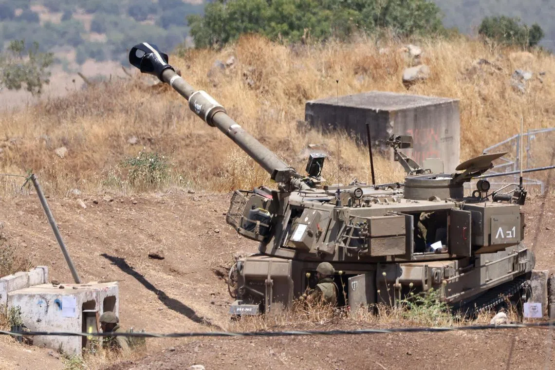 Av Israeli army self propelled artillery vehicle sits on the outskirts of Kiryat Shmona near Israel's border with Lebanon.