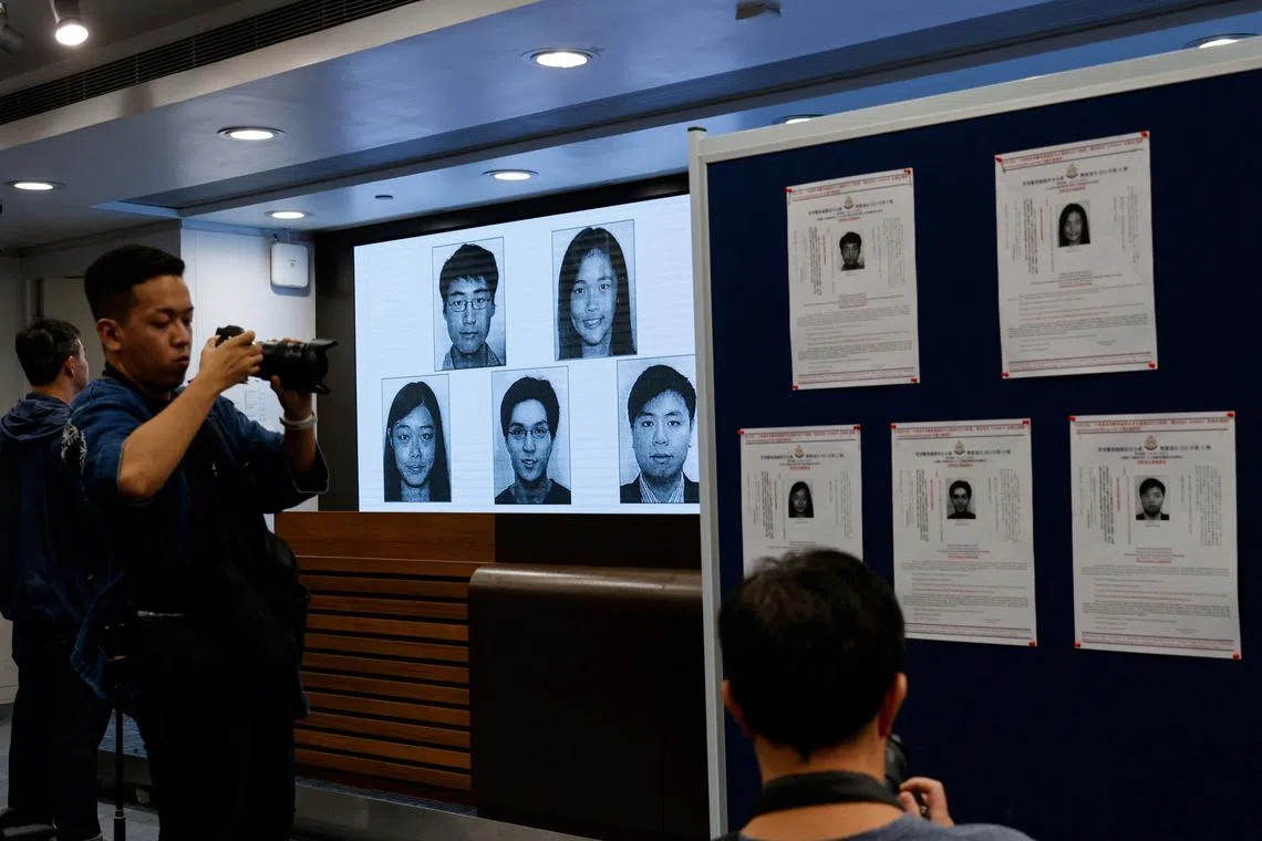 Images of five activists Simon Cheng, Frances Hui, Joey Siu, Johnny Fok, and Tony Choi are displayed during a press conference to issue arrest warrants.