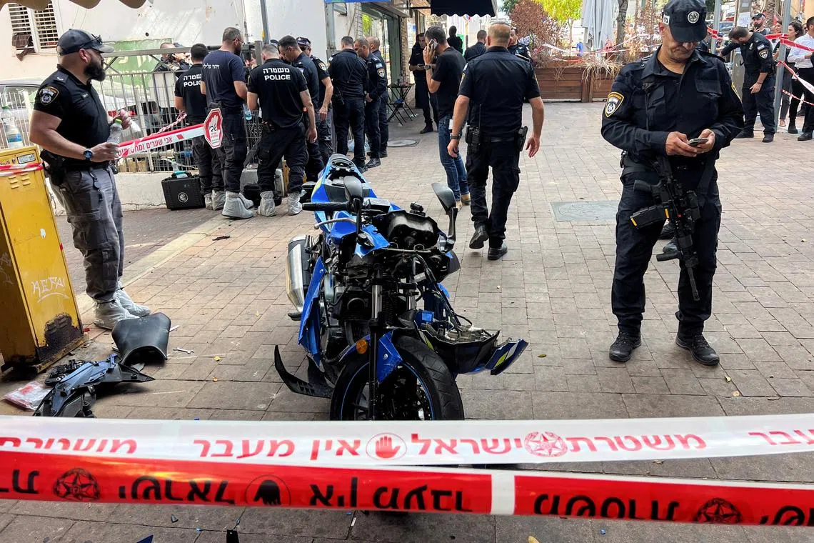 Israeli police stand around the motorbike of the attacker following a stabbing attack in Hadera, Israel, October 9, 2024. REUTERS/Miro Maman