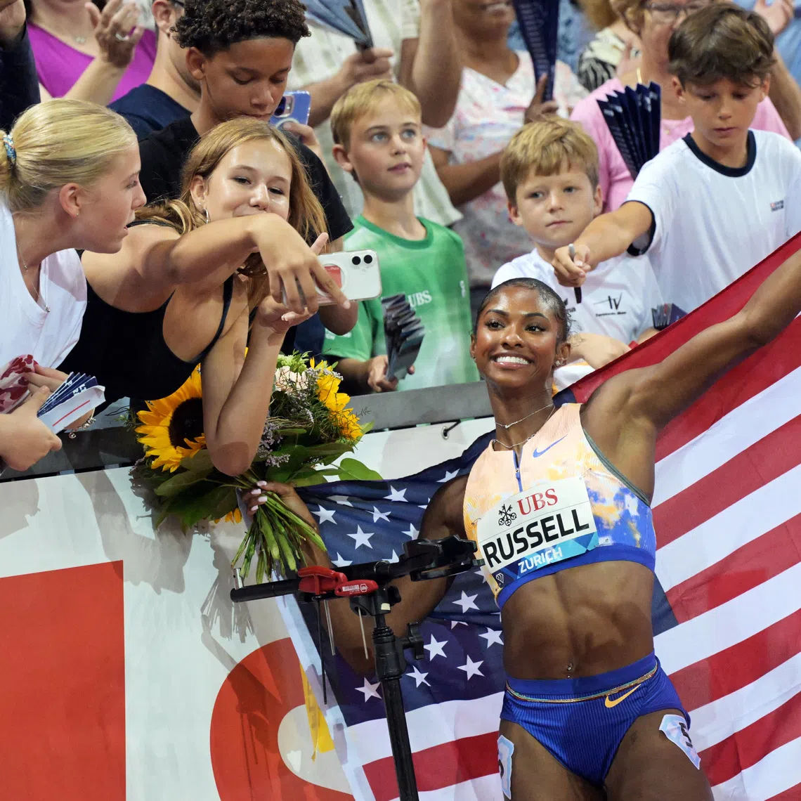 FILE PHOTO: Athletics - Diamond League - Zurich - Letzigrund, Zurich, Switzerland - August 27, 2026 Masai Russell of the U.S. poses for selfies with spectators after winning the women's 100m hurdles final and setting a new world record REUTERS/Romina Amato/File Photo