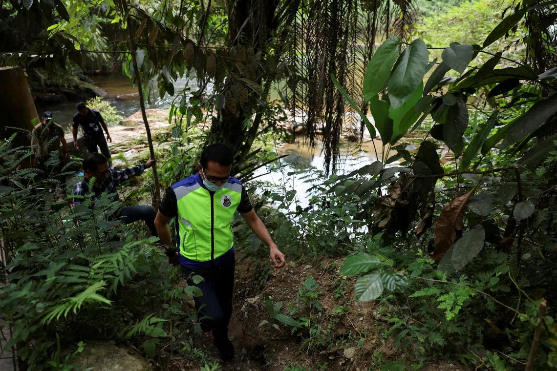 Malaysian immigration officers checking an area near an immigration detention centre in Perak where more than 100 Myanmar migrants escaped, in February 2024.