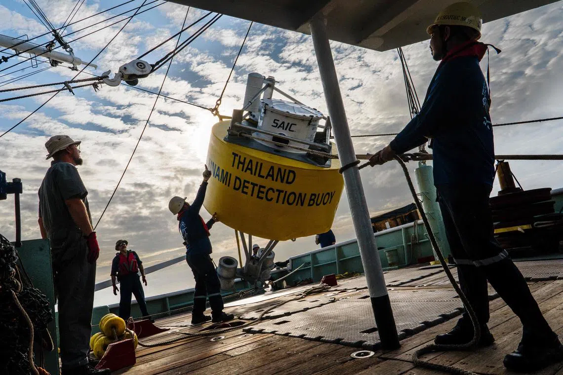 Each buoy floats on the surface while tethered to the seabed, monitoring signals from a seismic sensor on the ocean floor and changes in the water level.