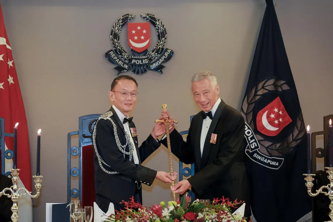 PM Lee Hsien Loong (right) receiving the Temasek Sword – the highest honour bestowed by the Singapore Police Force – from Commissioner of Police Hoong Wee Teck.