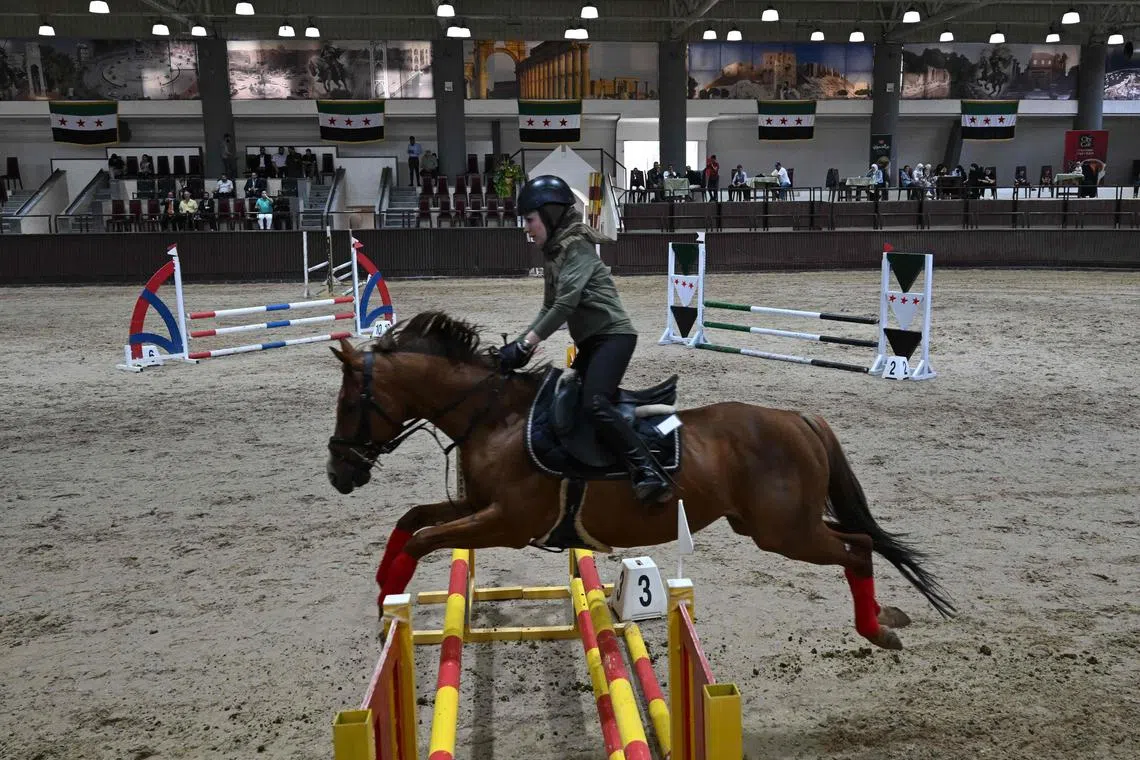 A horse rider competes during the fourth Al-Nasr Equestrian Show Jumping Championship at the Central Equestrian Club in Dimas, north-west of Damascus on May 9, 2025. For decades, equestrian sports were dominated by Syria's former ruling al-Assad family and their inner circle. But after the overthrow of Bashar al-Assad in a lightning Islamist-led offensive in December, new faces are competing amid growing interest in the sport. 