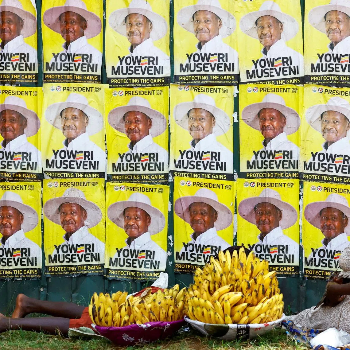 Women sell bananas near campaign posters of Uganda's President and the leader of ruling National Resistance Movement (NRM) party, Yoweri Museveni, following the general elections in Kampala, Uganda January 17, 2026. REUTERS/Thomas Mukoya