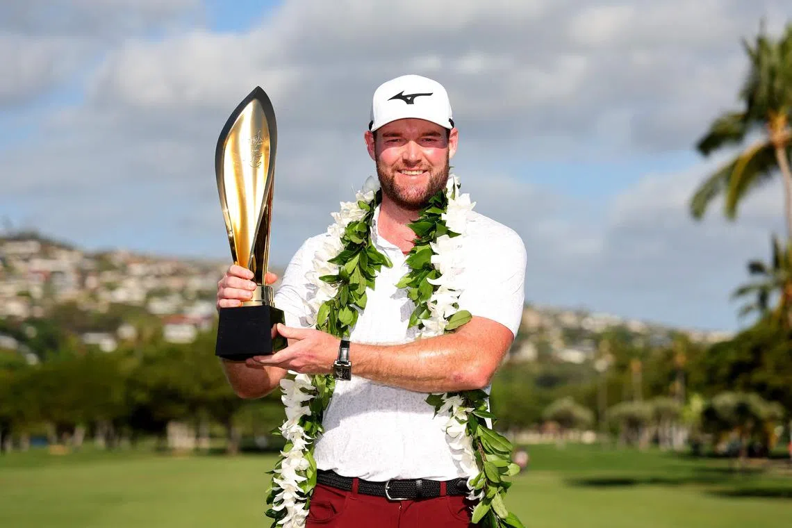 Grayson Murray posing with the championship trophy after victory on the first play-off hole during the final round of the Sony Open in Hawaii.