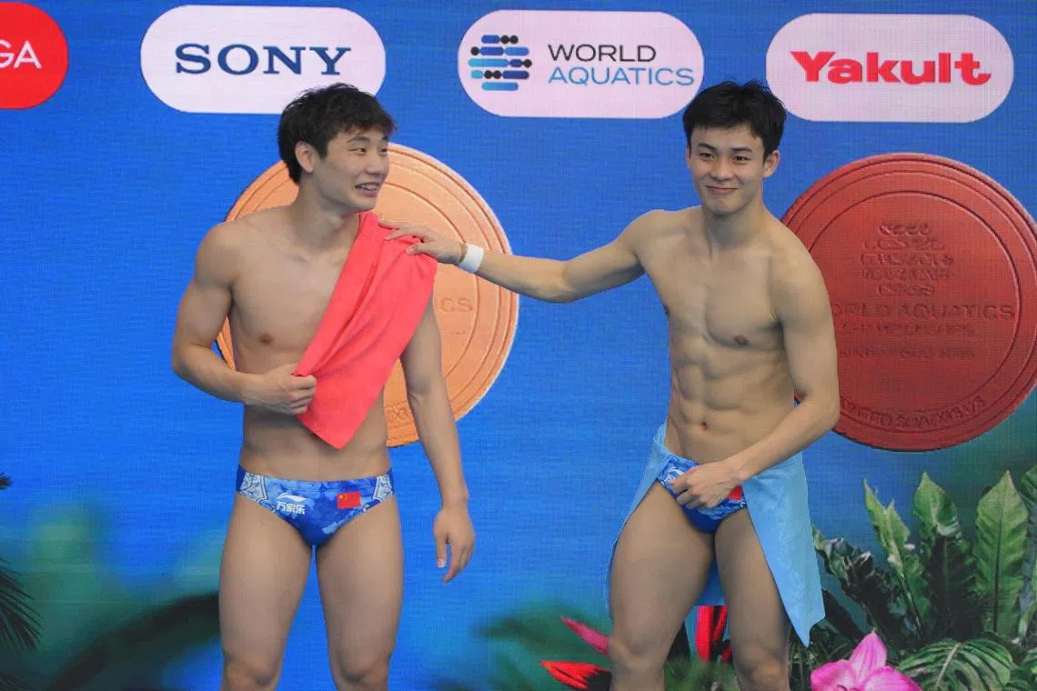 Bronze medalist Yan Siyu (right) of China congratulates his teammate Gold Medalist Zheng Jiuyuan of China after the Men's 1m Springboard final of the World Aquatic Championship held at the OCBC Aquatic Centre on July 27, 2025.